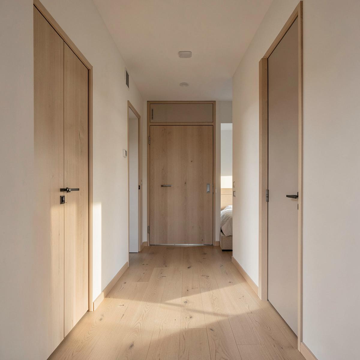 Pasillo y dormitorio de una vivienda reformada con puertas de madera clara